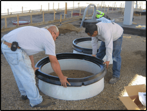 MwayPro Watertight Manhole Cover- two men placing parts on base